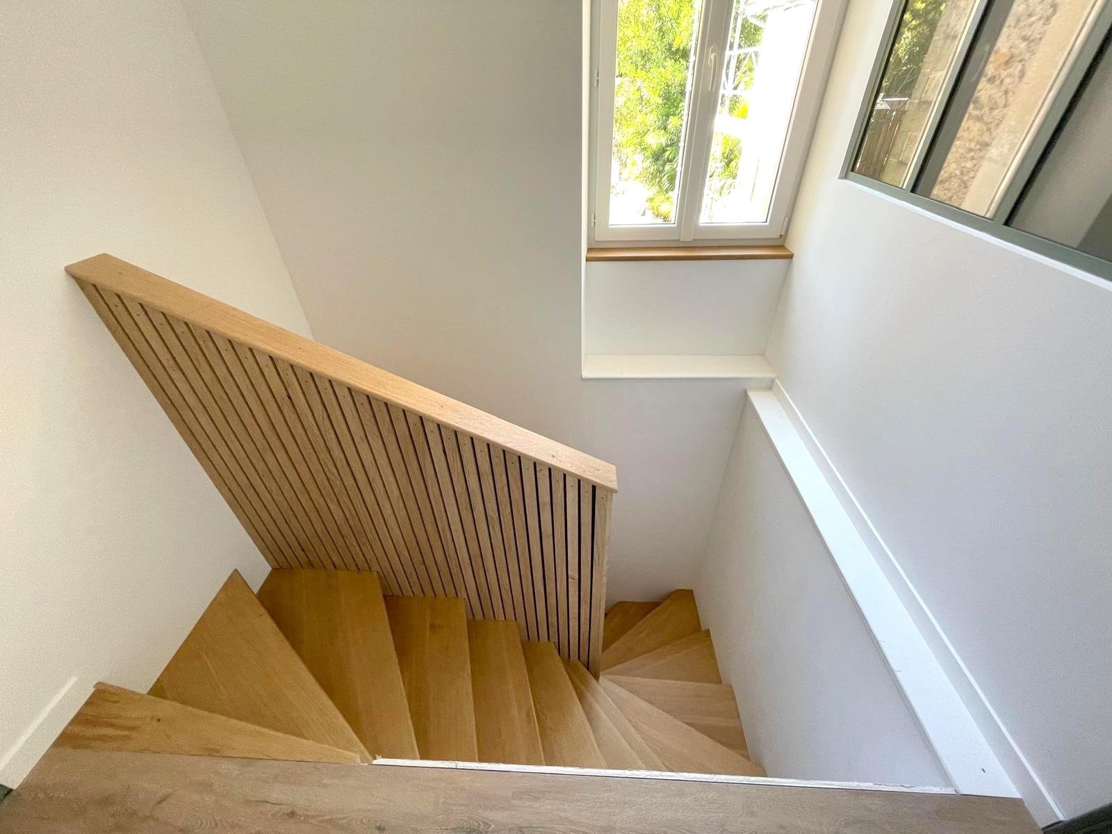 renovation escalier bois noyer claire voie Escalier en bois avec un garde-corps, vue plongeante depuis le haut.