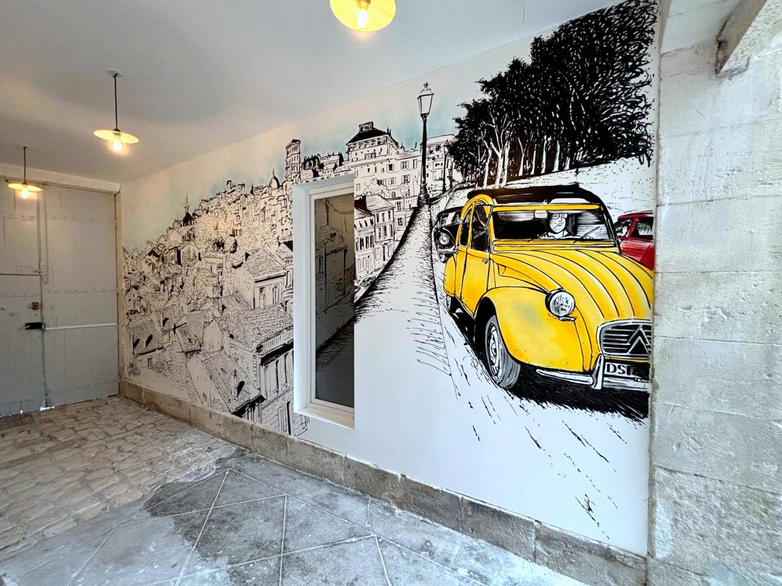 renovation maison de ville barbezieux - fresque murale Mural sur mur représentant une voiture jaune sur un fond monochrome et des paysages urbains.