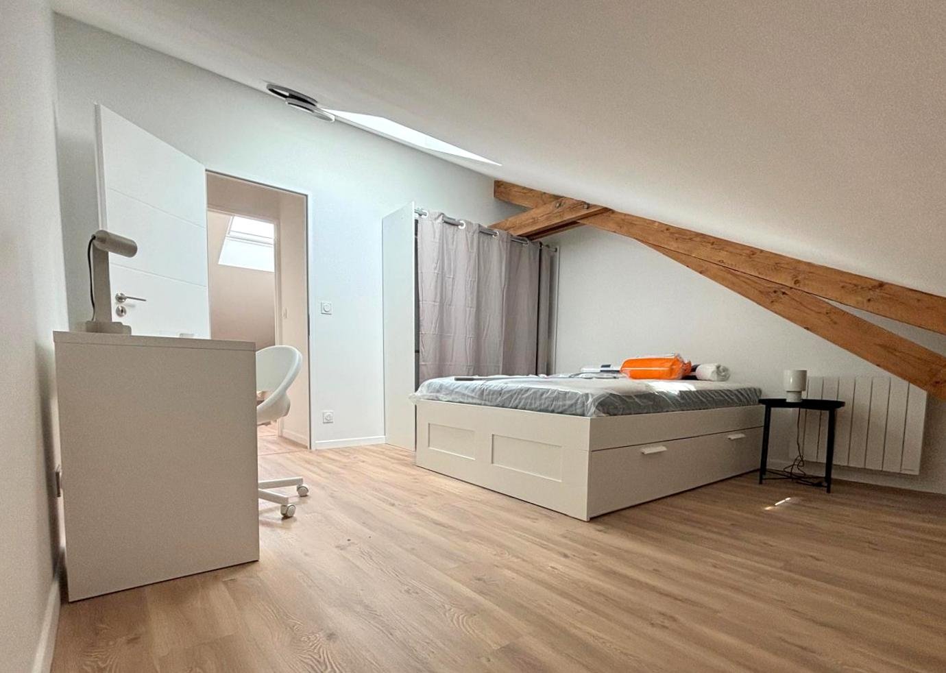amenagement combles perdus creation chambre cognac Chambre sous les combles avec lit, meuble de rangement et bureau.